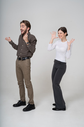 事務服を着た喜んでいる若いカップルの 4 分の 3 ビュー