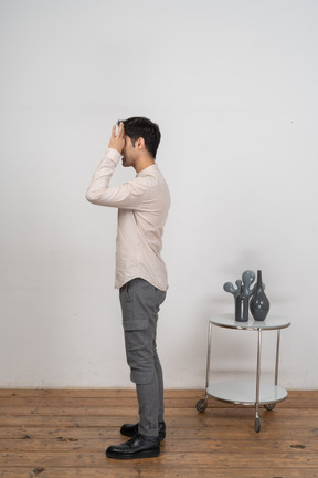 一个穿休闲服的男人的侧视图,透过手指看