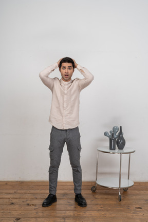 一个穿着休闲服、双手放在头后的印象深刻的男人的前视图