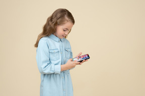 Ragazza carina guardando lo schermo del suo smartphone