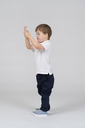 彼の手のひらを見ている少年の側面図