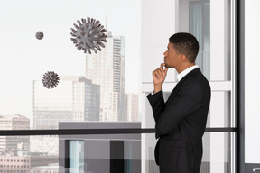 Man in a suit standing on a balcony with coronavirus cells on background